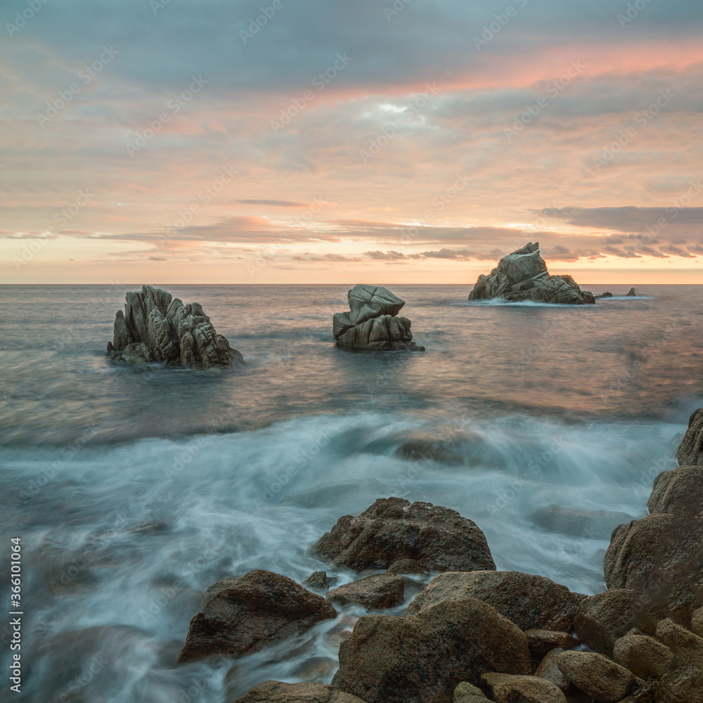 sunset in cala frares, on the path of ronda de lloret de mar, with some rocks with curious shapes