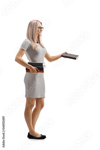 Full length profile shot of a blond woman giving a book