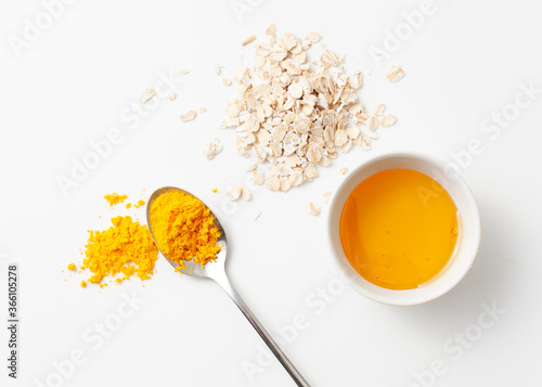 Recipe rejuvenating homemade face mask made of turmeric, honey and oatmeal on a white background.