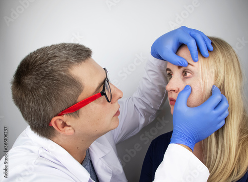 An ophthalmologist examines a woman who complains of a burning sensation and pain in her eyes. Eye fatigue from a computer screen or telephone (sand sensation on the cornea) photo