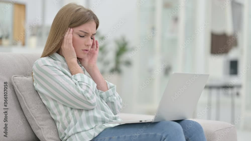 Stressed Young Woman with Laptop having Headache at Home Stressed Young Woman with Laptop having Headache at Home