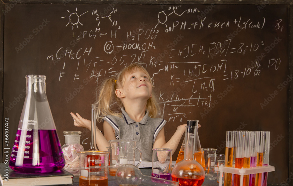 Curious little girl with test tubes and colorful substances makes tests at school laboratory. Small kid learning chemistry and conducts science experiment on biology lesson. Future microbiologist. Curious little girl with test tubes and colorful substances makes tests at school laboratory. Small kid learning chemistry and conducts science experiment on biology lesson. Future microbiologist.