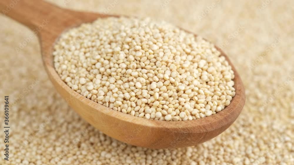 quinoa seeds in wooden spoon and on background rotating, top view quinoa seeds in wooden spoon and on background rotating, top view