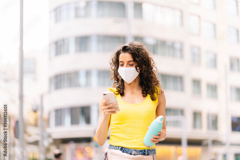 Woman with thermal bottle with smart phone in the city Woman with thermal bottle with smart phone in the city