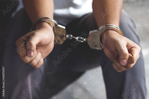 Prisoner man with handcuffs in his arms