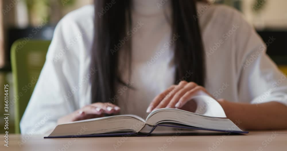 Hand Turning Pages of Book, unrecognizable girl reading at library Hand Turning Pages of Book, unrecognizable girl reading at library