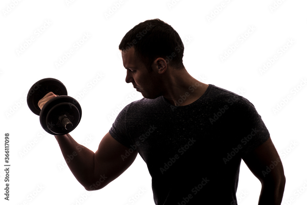 Silhouette of young man with 
dumbbell weight. Studio shot