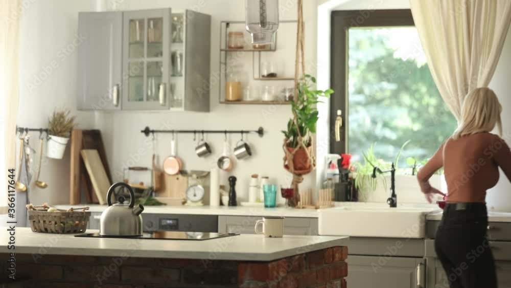 Blonde mother looking for something in a kitchen Blonde mother looking for something in a kitchen