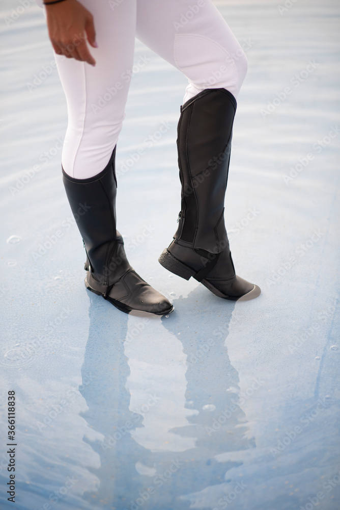 legs of a young woman in a cool fashion boots in a water