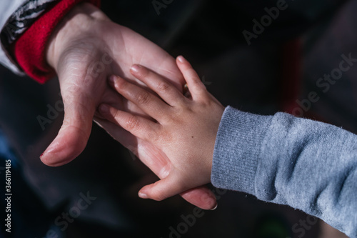 Hand of grandson is supported by grandma hand showing love and care © Sin Filtro