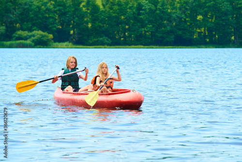 Children siblings girl and boy (brother and sister) kayaking on vacation 