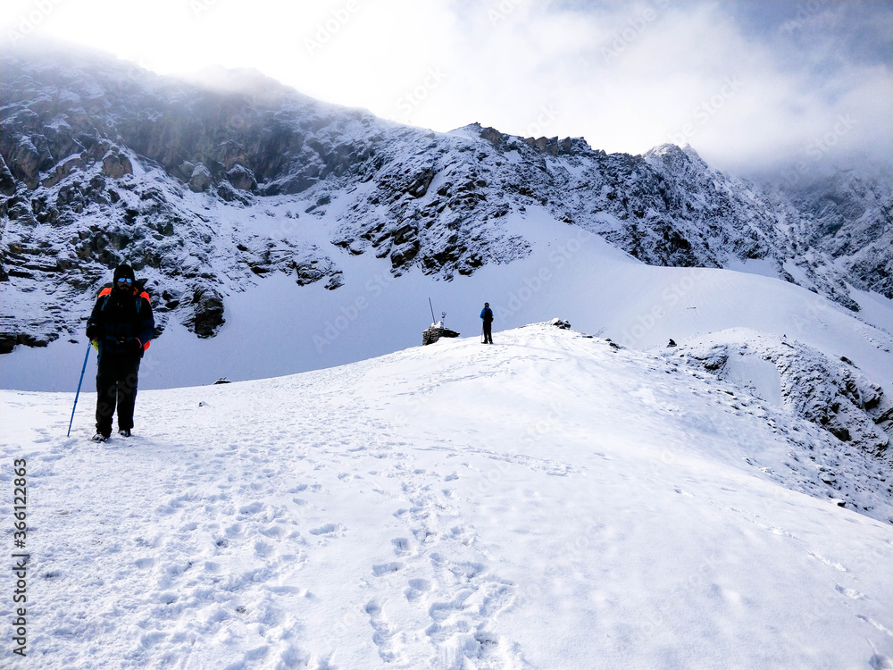 Wan, Indian - June 2nd 2018: Well Equipped Hiker walking on a huge blanket of snow to reach top of the Indian Himalayan Mountain.