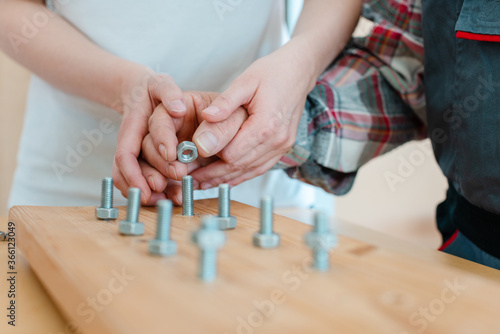 Closeup of man in occupational therapy screwing nut on bolt photo