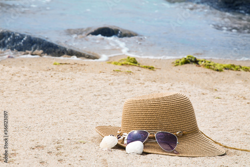 hat, sunglasses and shells on the beach, summer vacation concept