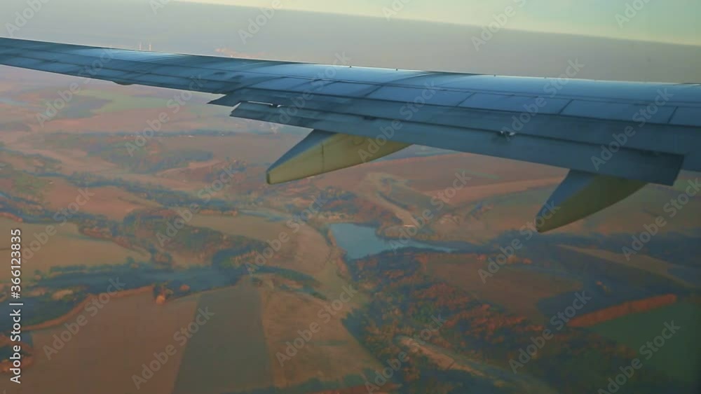 aerial view from aircraft window on airplane wing fly above low brown mountains aerial view from aircraft window on airplane wing fly above low brown mountains