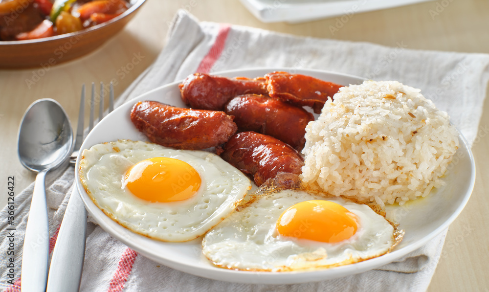 filipino silog breakfast with garlic fried rice, longsilog, and two sunny side up eggs filipino silog breakfast with garlic fried rice, longsilog, and two sunny side up eggs