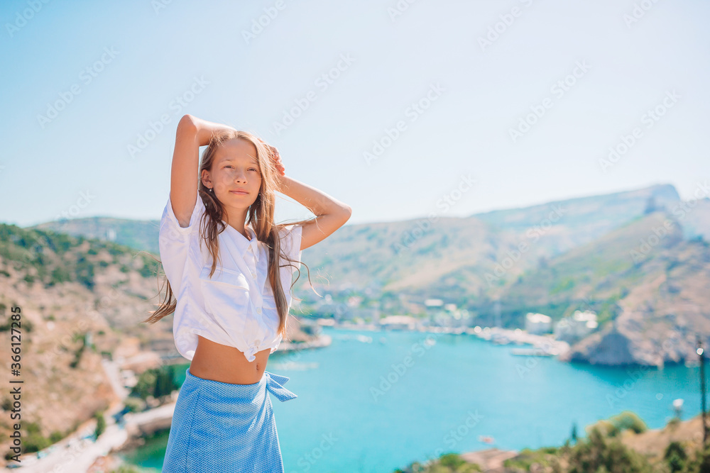 Little girl on top of a mountain enjoying valley view