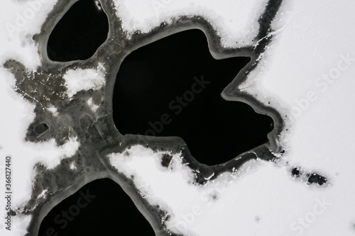 Flying above ice  top down aerial view of ice floes in the lake.