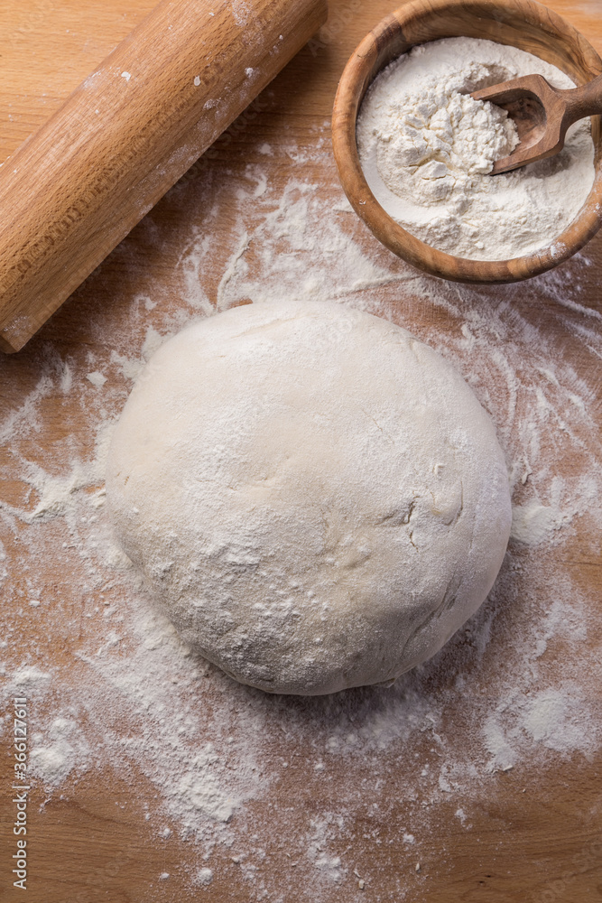 Homemade yeast dough freshly prepared for pizza or bread on wooden background. Homemade yeast dough freshly prepared for pizza or bread on wooden background.