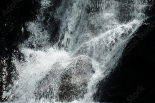 Wasserfall strömt mit viel Gischt auf Felsen