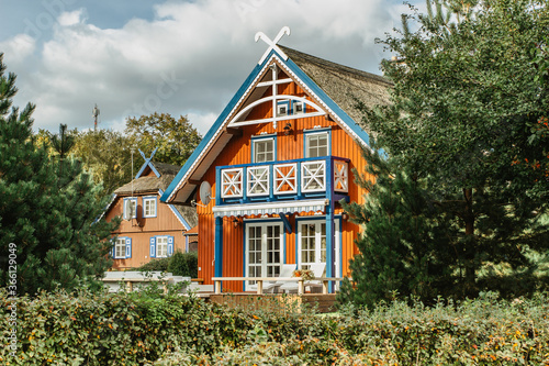 Beautiful colorful Lithuanian traditional wooden houses. Typical fisherman's house in the Baltics.Red wooden houses on the Curonian Spit.Lifestyle real estate concept