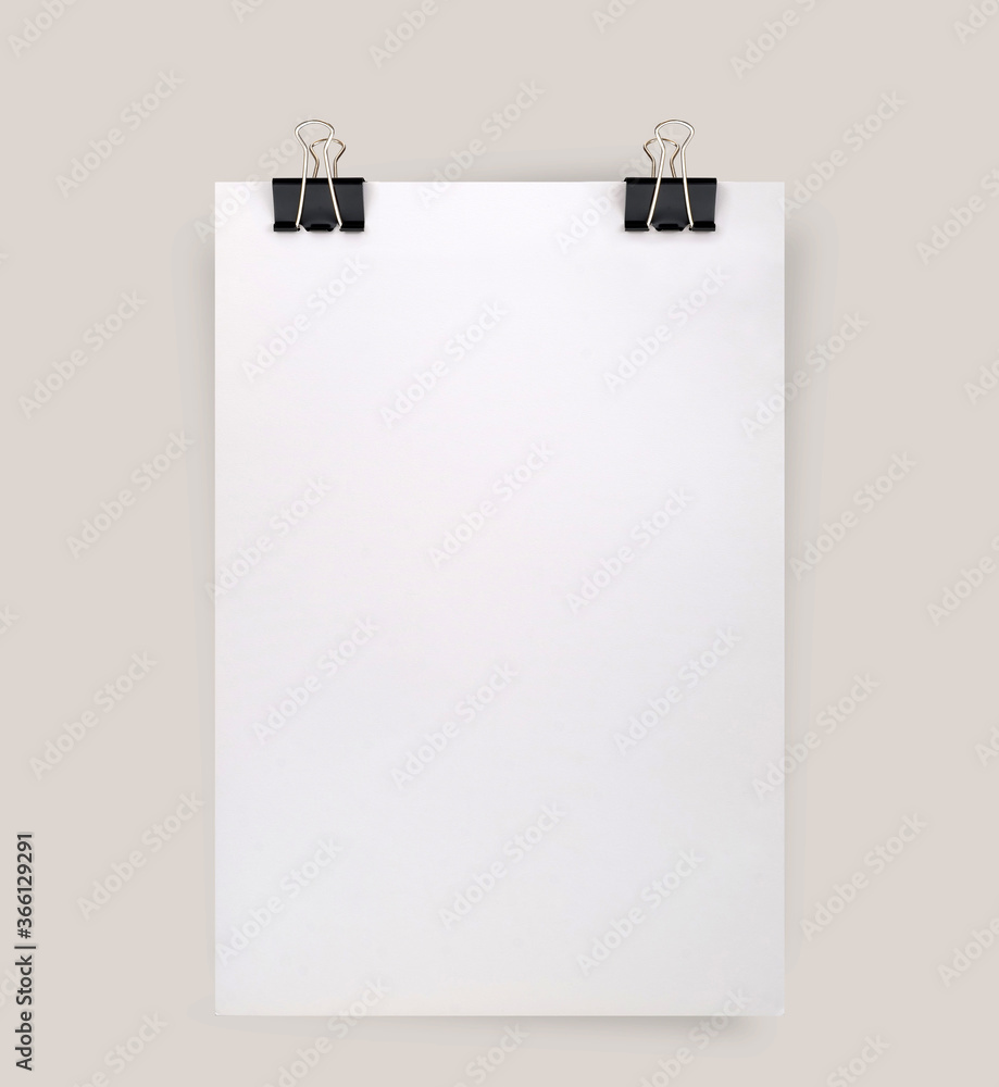 Sheet of paper with binder clips isolated on a gray background Sheet of paper with binder clips isolated on a gray background