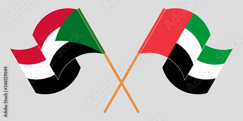 Crossed and waving flags of Sudan and the United Arab Emirates