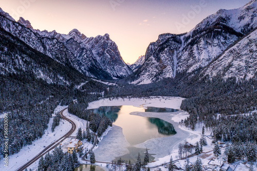 Sunrise over the icy Lake Dobbiaco and woods in winter, Dobbiaco, Val Pusteria, Dolomites, Bolzano province, South Tyrol photo