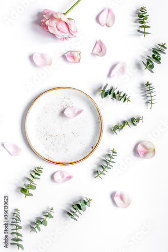 rose petals and eucalyptus on white table top view mock up