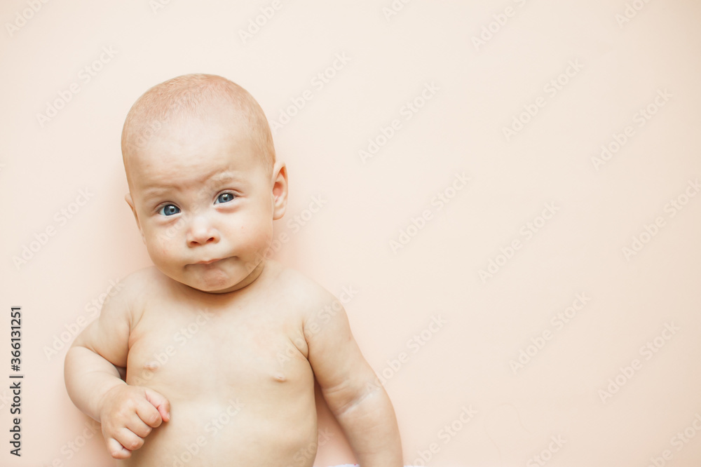 Little cute baby lies on a light pink background. Little cute baby lies on a light pink background.