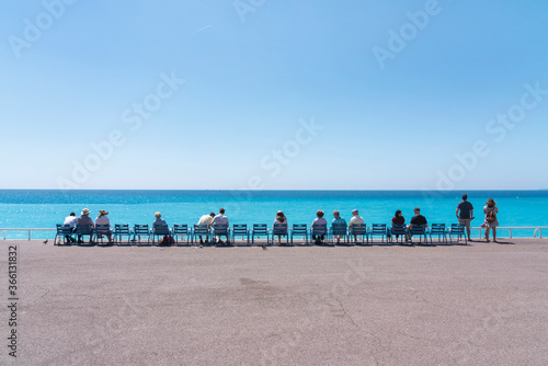 Line of people on chairs looking out to the sea, Nice, Alpes Maritimes, Cote d'Azur, French Riviera, Provence photo