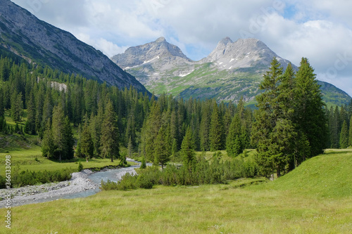 Aussicht auf Berggipfel im Lechquellengebirge mit Alpenwiese und Lech Fluss im Vordergrund