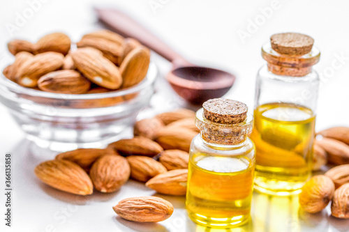natural oil and almond in cosmetic set on table background