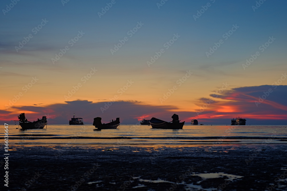 Boote liegen im Meer am Strand vor Sonnenuntergang