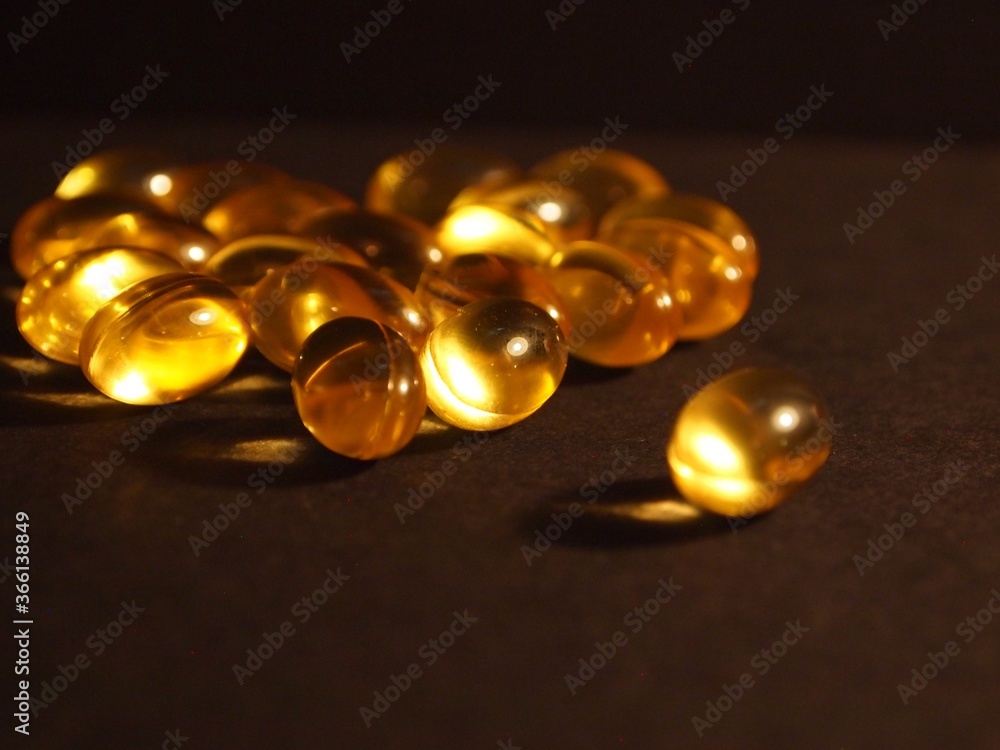 Trans-lucid cod liver oil pills under colourful light Trans-lucid cod liver oil pills under colourful light