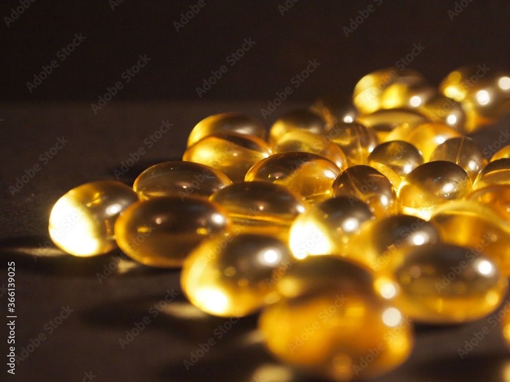 Trans-lucid cod liver oil pills under colourful light Trans-lucid cod liver oil pills under colourful light