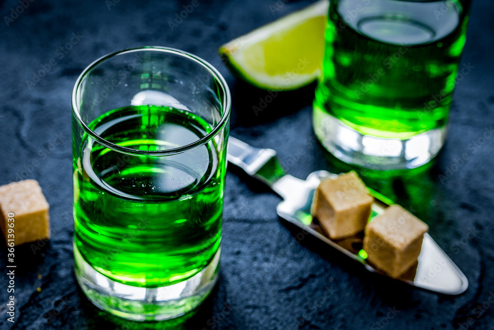absinthe shots with lime slices and sugar on dark table background absinthe shots with lime slices and sugar on dark table background