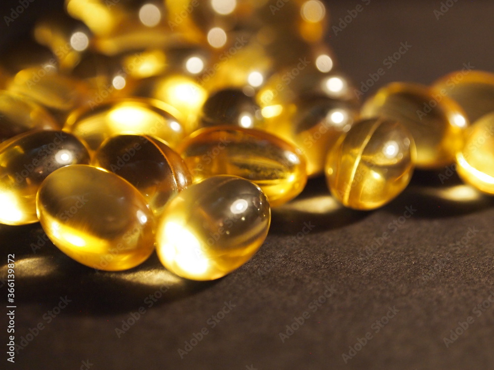 Trans-lucid cod liver oil pills under colourful light Trans-lucid cod liver oil pills under colourful light
