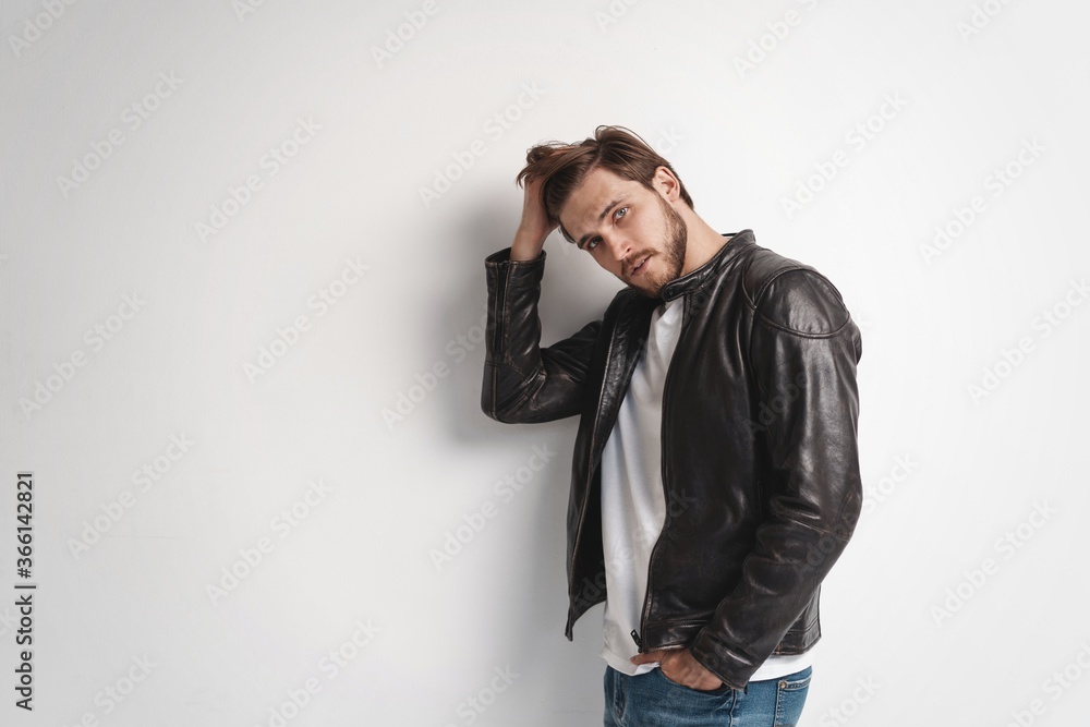 Fashion man, Handsome serious beauty male model portrait wear leather jacket, young guy over white background Fashion man, Handsome serious beauty male model portrait wear leather jacket, young guy over white background