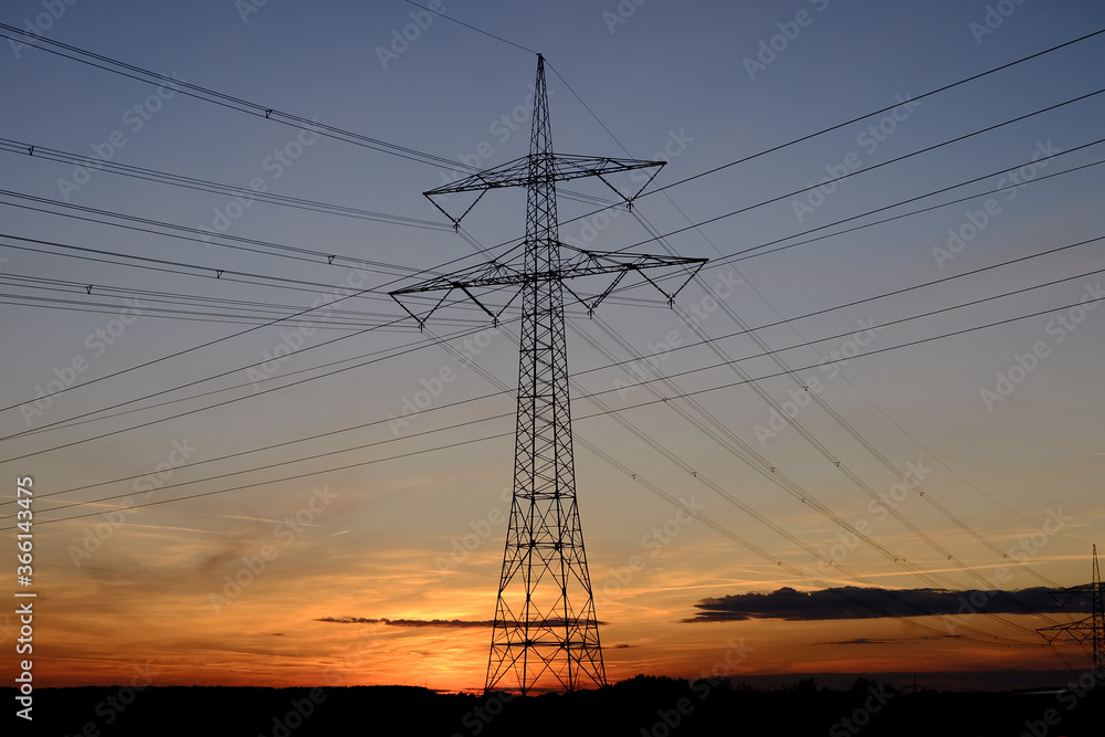 Strommast mit Kabeln vor Sonnenuntergang