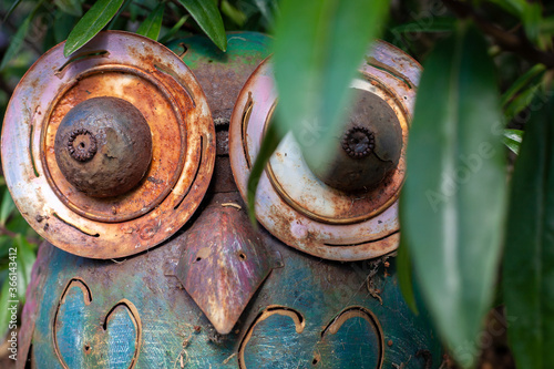 Принти на полотні Rusty Metal Owl in Garden Looking Through Leaves