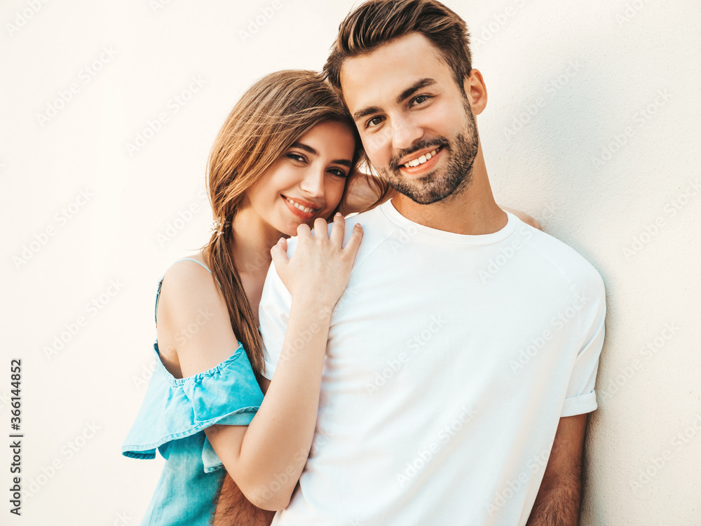 Naklejka premium Portrait of smiling beautiful woman and her handsome boyfriend. Woman in casual summer jeans dress. Happy cheerful family. Female having fun. Couple posing on the street background in sunglasses