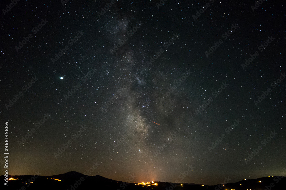 Milky way raising over San Quirico on a summer night in Val d'Orcia, Tuscany, Italy