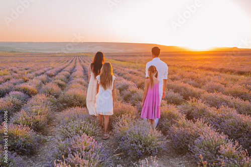 Family in lavender flowers field at dawn