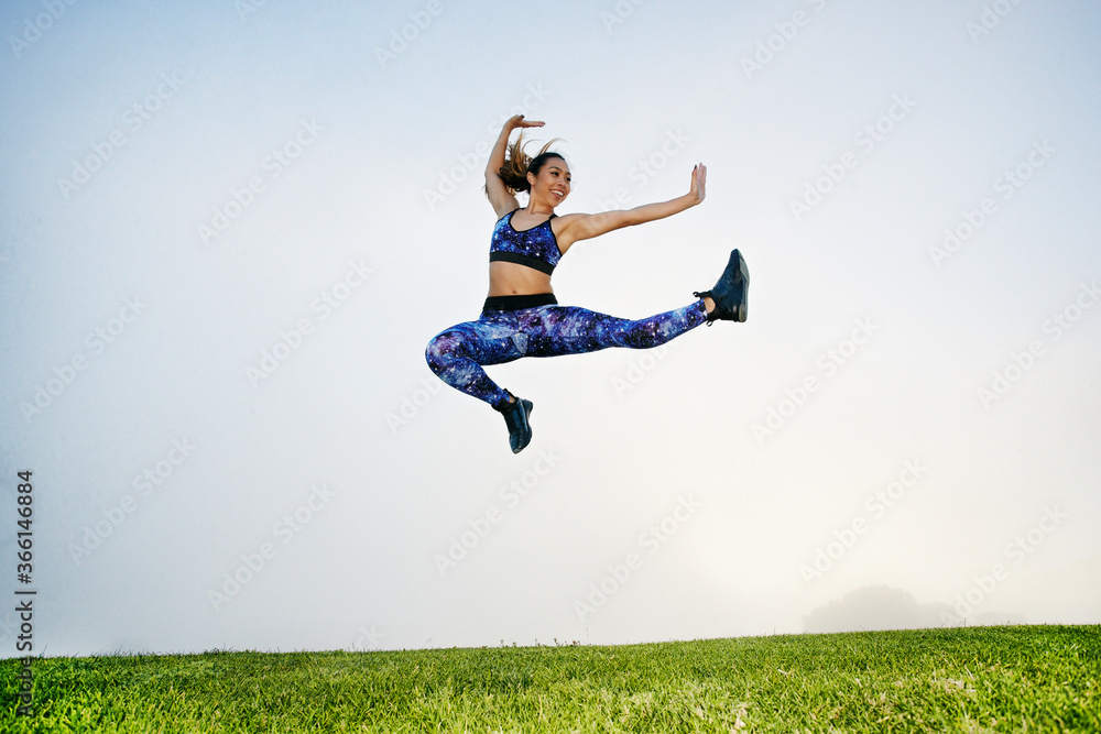 Mixed race woman exercising and jumping in field Mixed race woman exercising and jumping in field