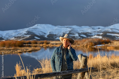 USA, Idaho, Sun Valley, Senior man in cowboy using smartphone photo