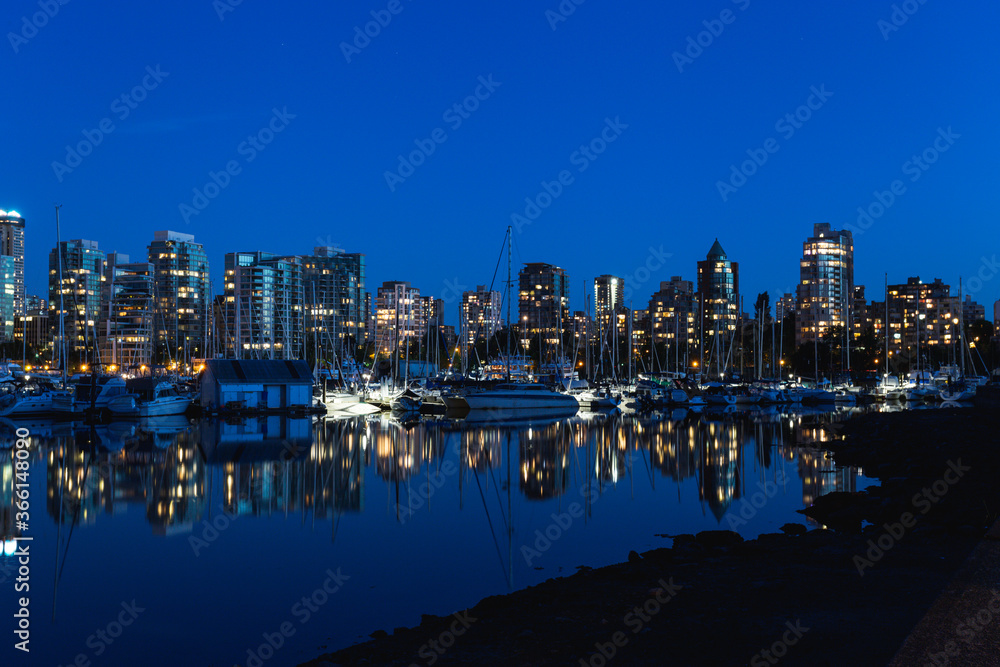 reflection of buildings on very calm water in a city at dawn