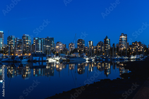 reflection of buildings on very calm water in a city at dawn