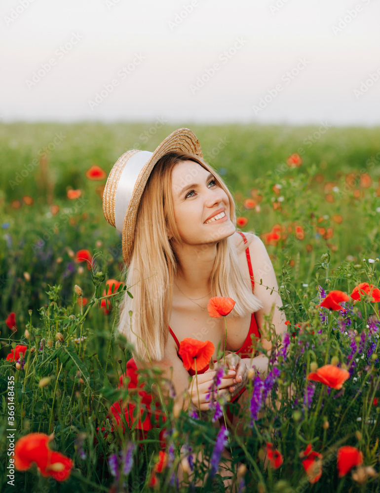 Aesthetic blonde in a red dress posing on a poppy field Aesthetic blonde in a red dress posing on a poppy field