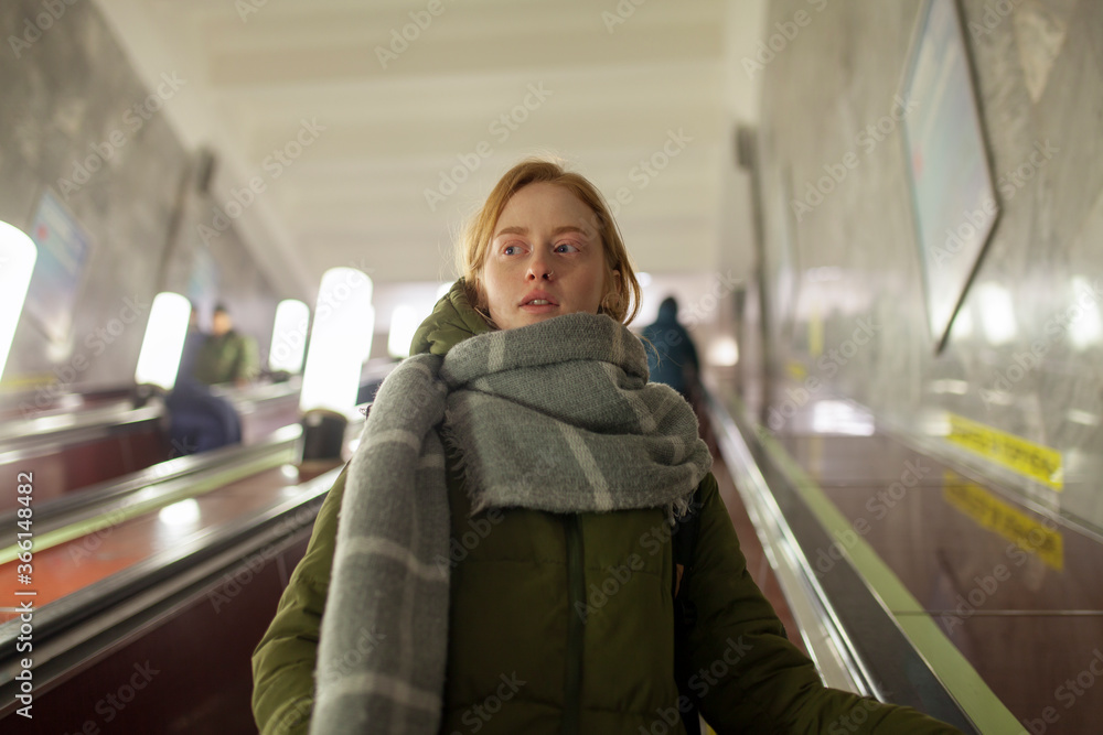 Russia, Novosibirsk, Young woman standing on escalator Russia, Novosibirsk, Young woman standing on escalator